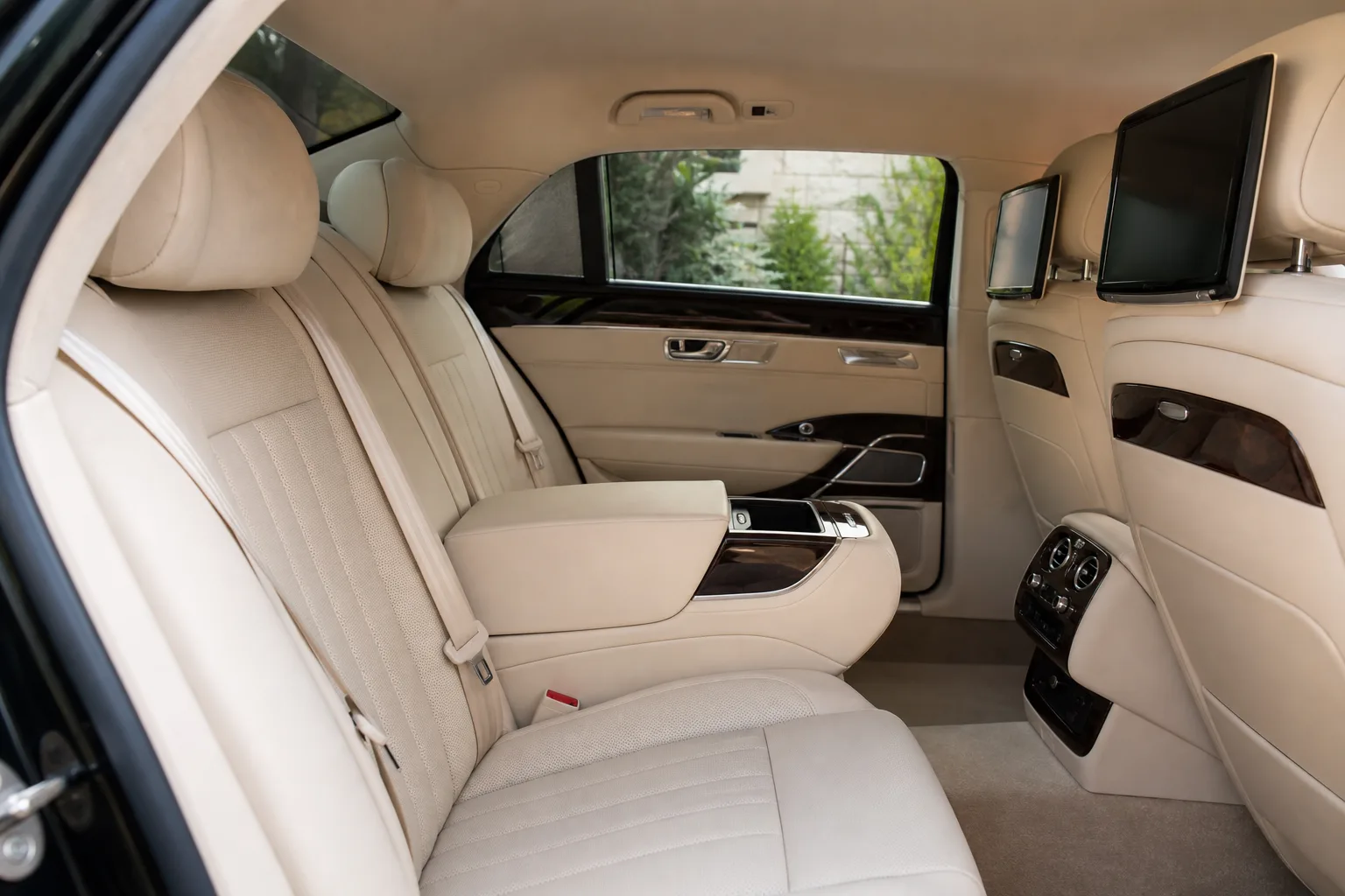 The refined cream leather interior of a chauffeur-driven car